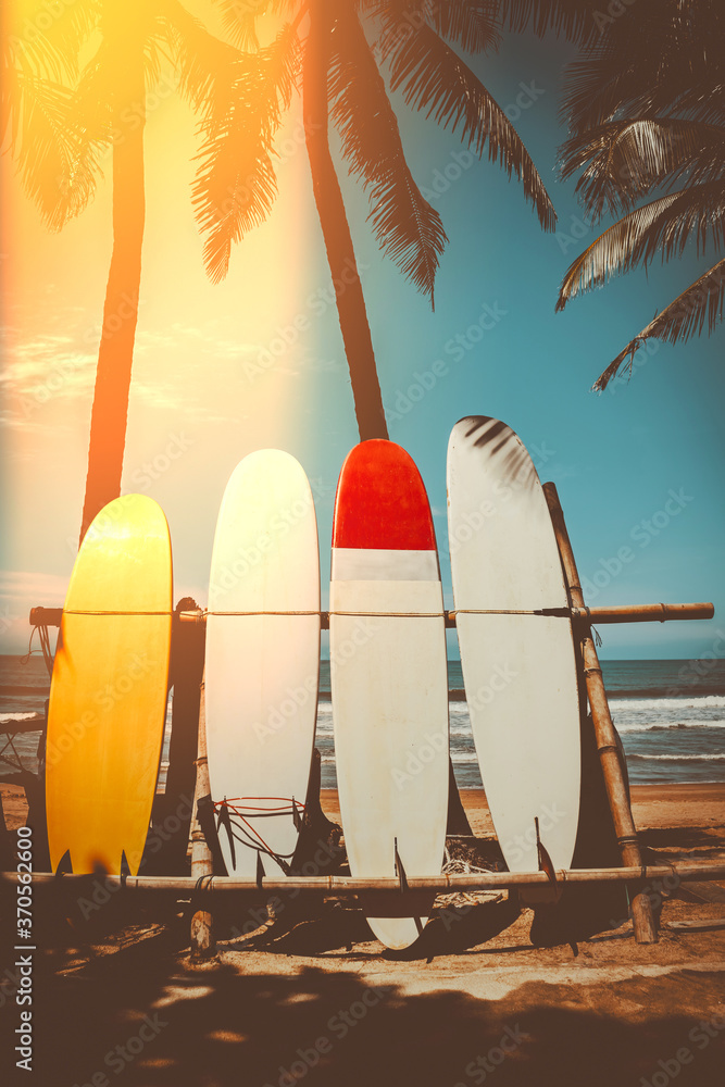 Surfboard and palm tree on beach background. - obrazy, fototapety, plakaty 