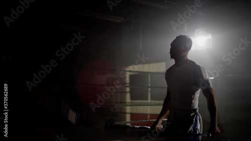 Wallpaper Mural Physically fit Muay Thai fighter skipping in gym beside boxing ring, training backlit with flares in the background Torontodigital.ca