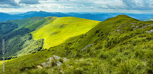 Fototapeta Naklejka Na Ścianę i Meble -  Mountain landscape with blue sky and green grassy meadow.