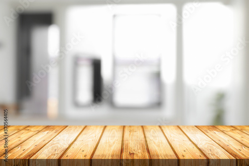 Empty wooden desk space and blurry background of home window for product display montage. © qOppi