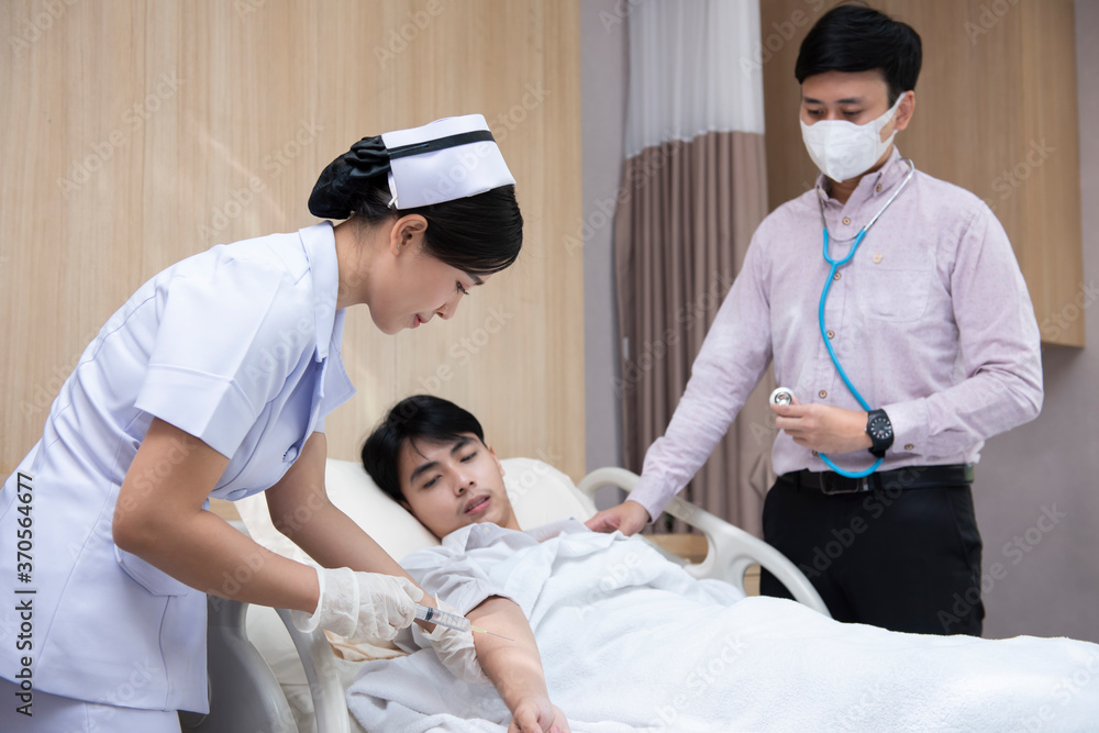 Asian woman nurse inject vaccine to patient. Doctor with stethoscope to coronavirus pneumonia signs. Physician checking chest of guy at the hospital. Asian woman nurse inject vaccine to patient. Doctor with stethoscope to coronavirus pneumonia signs. Physician checking chest of guy at the hospital.