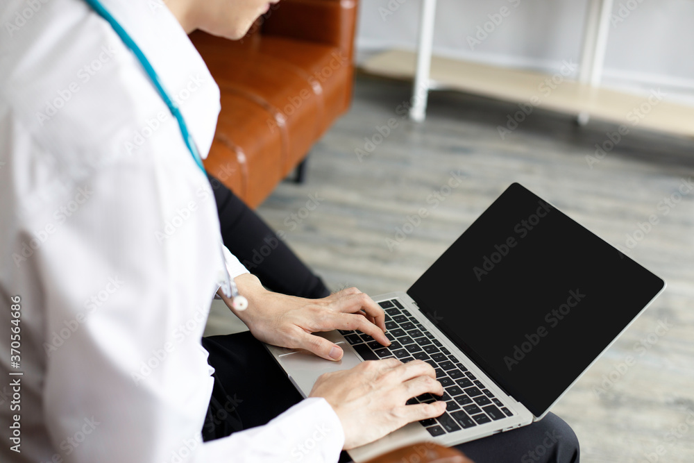 Male doctor in uniform are using laptops for medical work at modern hospital. empty monitor for your design. Laptop mockup. Male doctor in uniform are using laptops for medical work at modern hospital. empty monitor for your design. Laptop mockup.