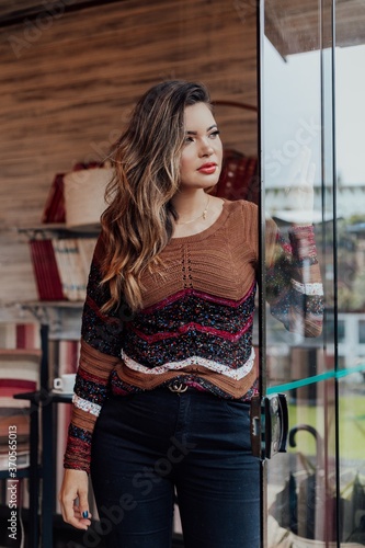 Beautiful model posing for photos in a room. Wearing black pants and brown blouse.  © Erica