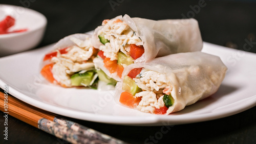 Food banner. Rice spring rolls with crab meat and vegetables on a white plate and bamboo sticks. Vietnamese seafood cuisine