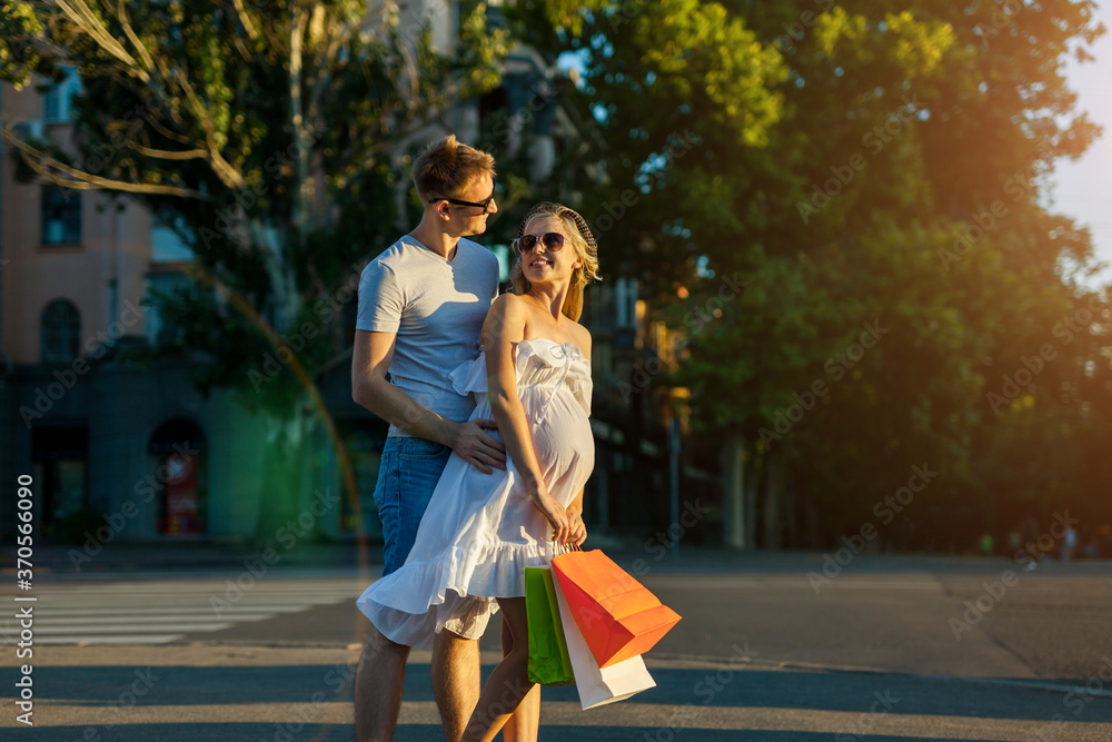 Fototapeta premium husband and pregnant wife shopping in city street