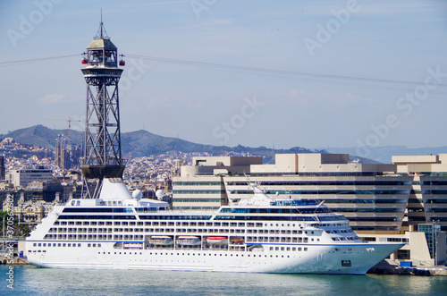 Luxuskreuzfahrtschiff vor der Skyline von Barcelona - Luxury cruiseship or cruise ship liner with skyline of Barcelona, Spain during Mediterranean cruises photo