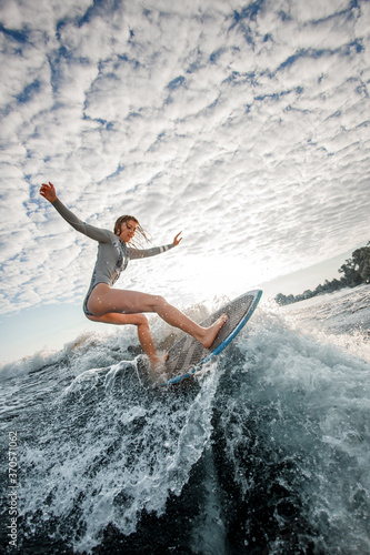 Sporty young woman ride wakesurf on the wave
