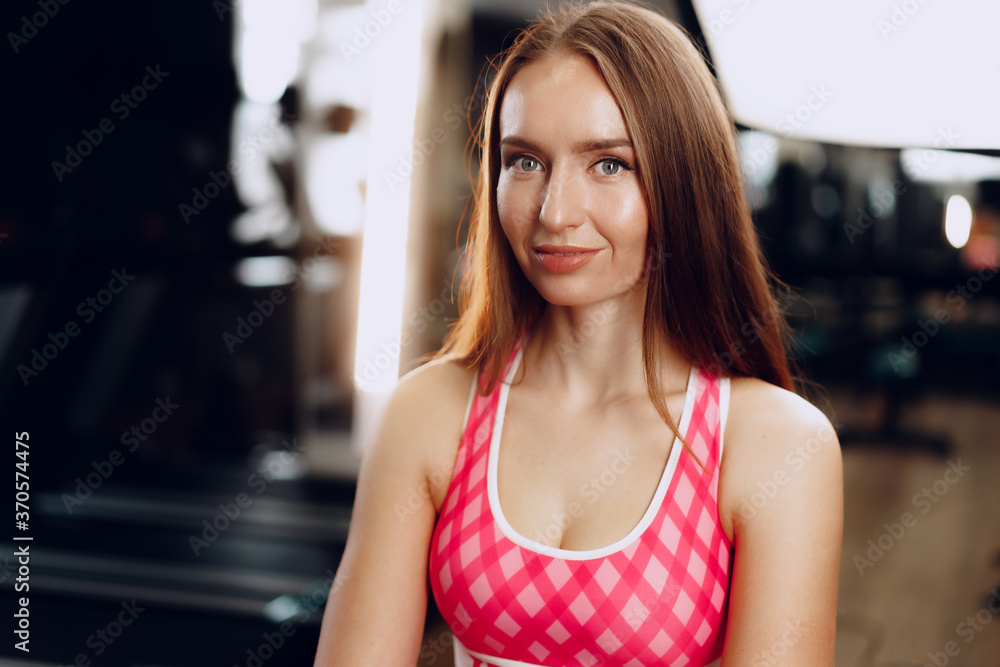 Young beautiful woman in sportswear in a gym