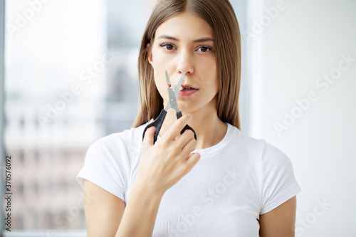 Stop smoking  young woman cuts a cigarette with scissors