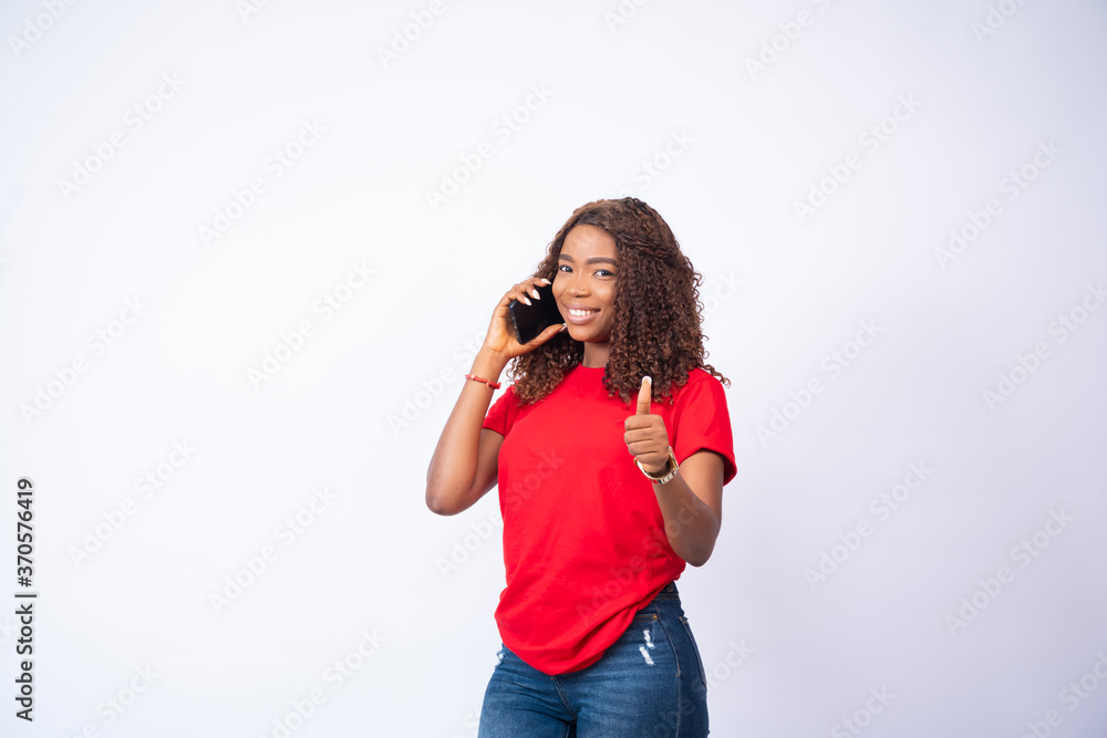 beautiful young black girl making a phone call giving a thumbs up beautiful young black girl making a phone call giving a thumbs up