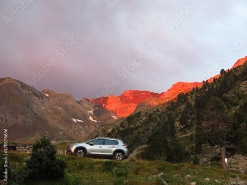 Voiture et soleil couchant sur la montagne © Ourson+