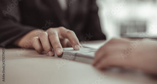 Young women give money to a company employee for bribery