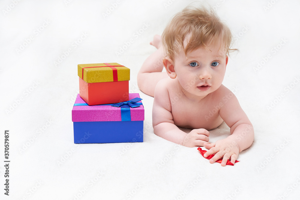 Cute smiling baby boy with gift box on light background Cute smiling baby boy with gift box on light background