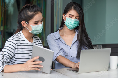 Two Asian young woman wearing medical mask to protect coronavirus while working at the outside