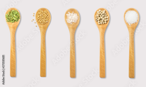 Herbs and spices and seeds on spoons on a white background