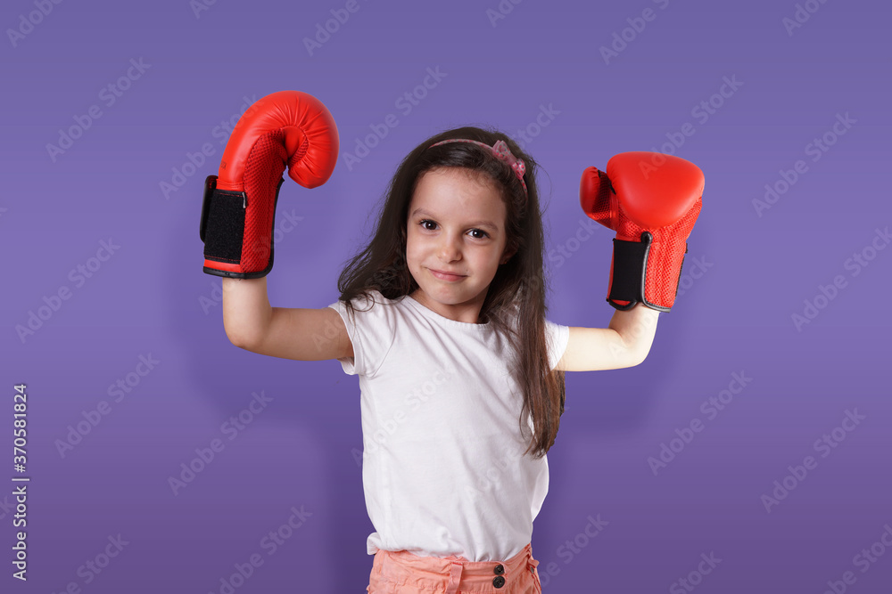 Beautiful young little girl wearing a pair of boxing gloves Beautiful young little girl wearing a pair of boxing gloves