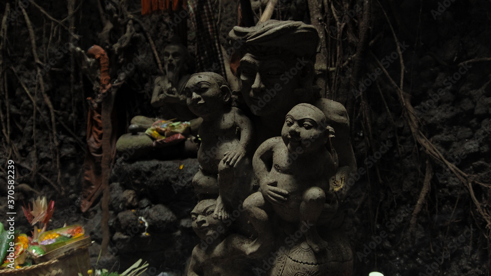 Religious place for rites with ancient statues of people in a dark cave with strong shadows