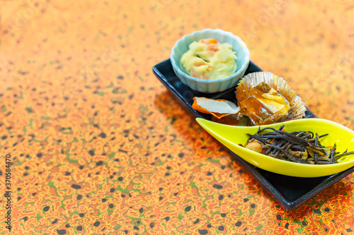 Japanese traditional cuisine of hijiki brown sea vegetables, Nikogori jellied fish aspic, Satsuma-age fried fishcake and potato salad. photo