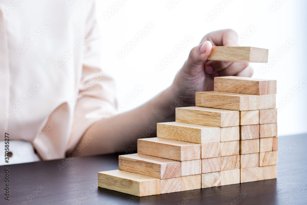 A woman arranging wooden blocks The idea of doing business to grow steadily. A woman arranging wooden blocks The idea of doing business to grow steadily.