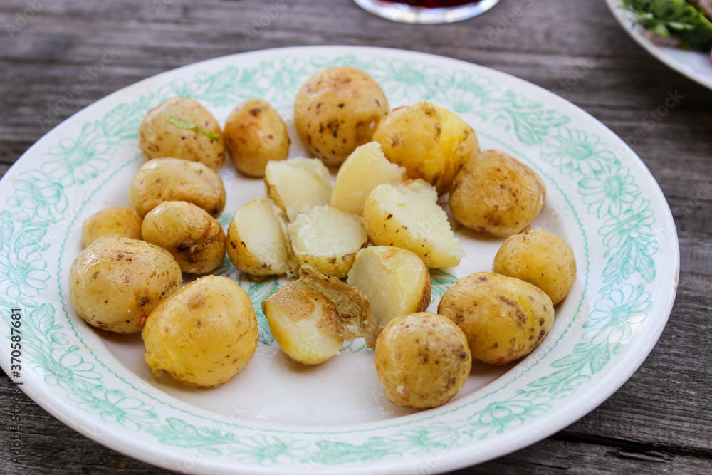 Round new potatoes fried to Golden brown with tomatoes, herbs and lettuce Round new potatoes fried to Golden brown with tomatoes, herbs and lettuce