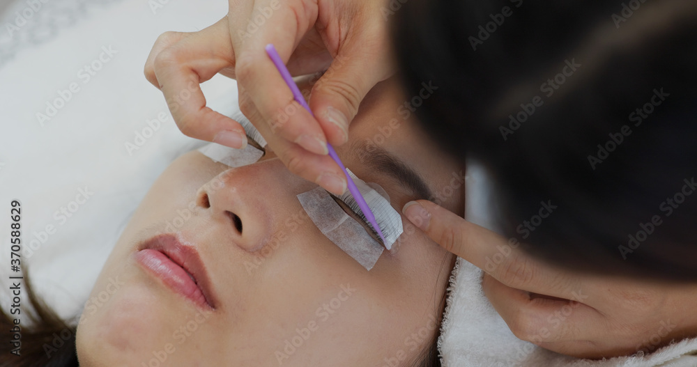 Woman perm her eyelash at beauty salon Woman perm her eyelash at beauty salon