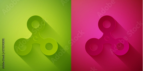 Paper cut Fidget spinner icon isolated on green and pink background. Stress relieving toy. Trendy hand spinner. Paper art style. Vector.