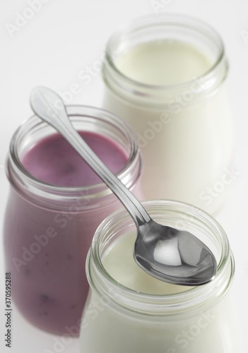Glasses of Natural and Raspberry Yoghurt against White Background