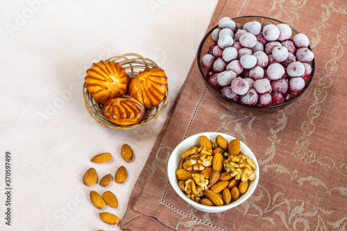 Frozen cherry and almond nuts for breakfast. Every day healthy breakfast. Beige and brown linen background. Flat lay