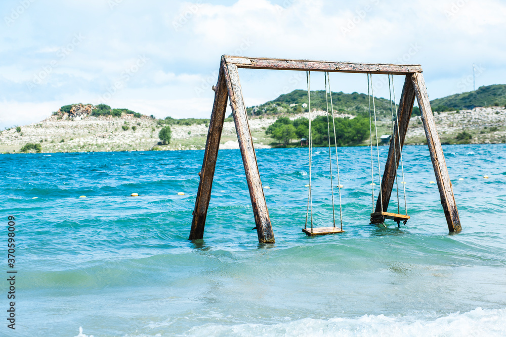 Wooden swing on  lake. solitude concept. swing stand in the middle  pond.