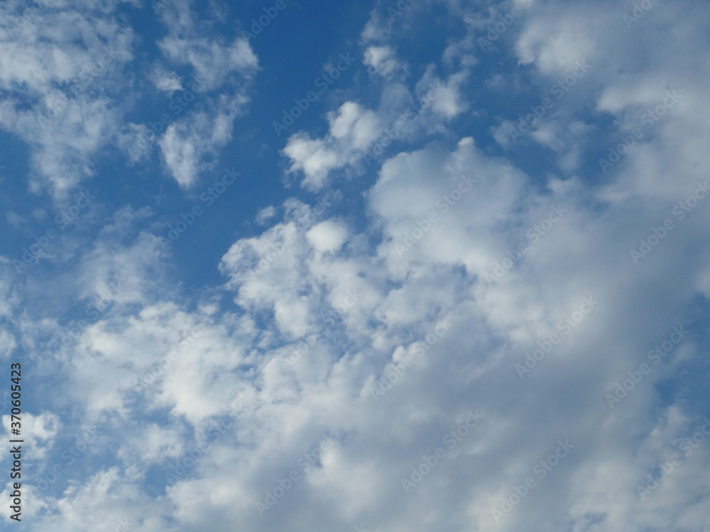 The blue cloudy sky with white clouds background and texture The blue cloudy sky with white clouds background and texture