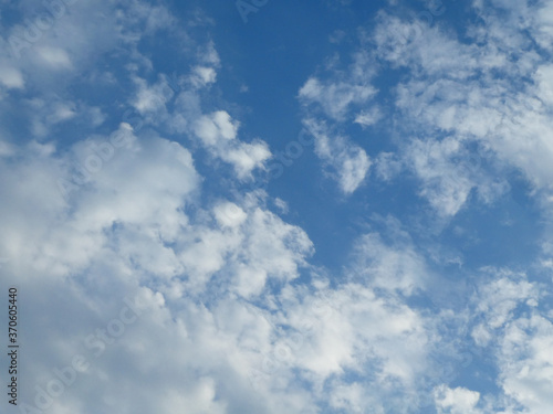 The blue cloudy sky with white clouds background and texture