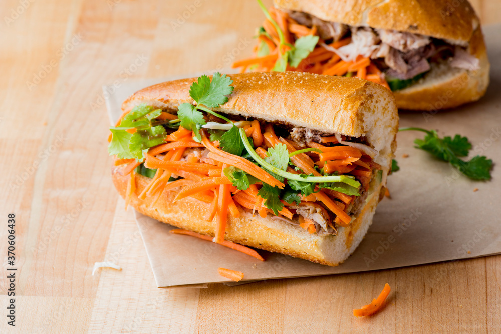Bánh mì or banh mi, Vietnamese word for bread. Traditional classic Vietnamese cuisine. Baguette with pate, pulled pork, jalapenos, cilantro, carrots cucumbers and spicy sauce. Bánh mì or banh mi, Vietnamese word for bread. Traditional classic Vietnamese cuisine. Baguette with pate, pulled pork, jalapenos, cilantro, carrots cucumbers and spicy sauce.