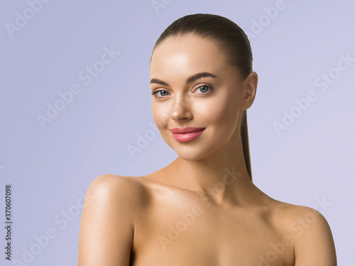 Clean skin woman face close up skin beauty tanned face beautiful smile over blue background