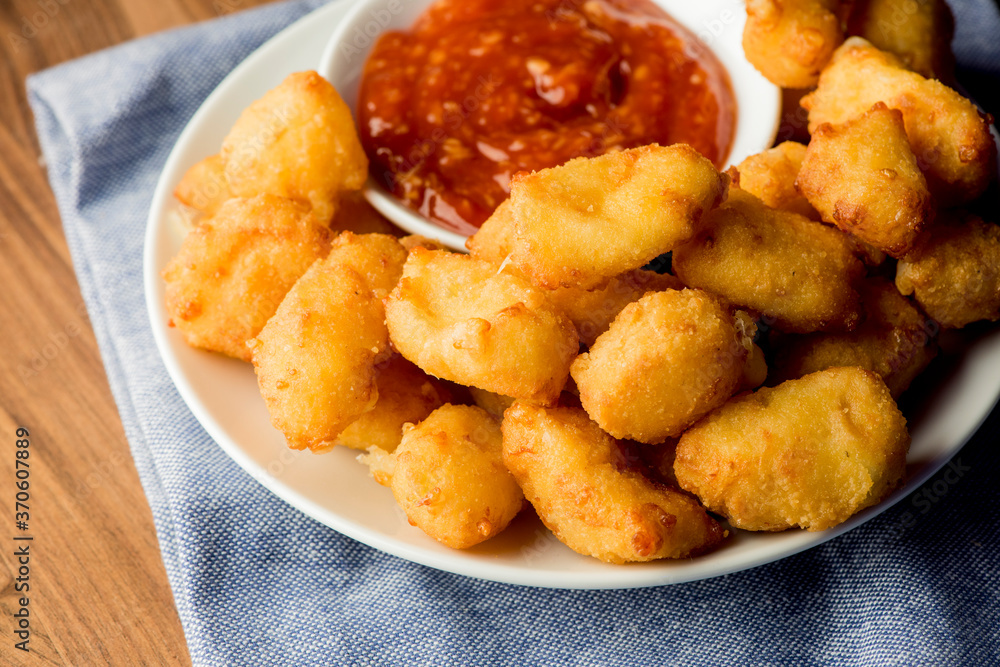 Breakfast sandwich. Bacon, fried egg, lettuce, tomato and onion on a bun being smashed by a waitresses hand. Action shot.