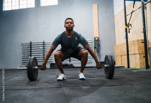 Crossfit athlete doing exercise with a barbell.