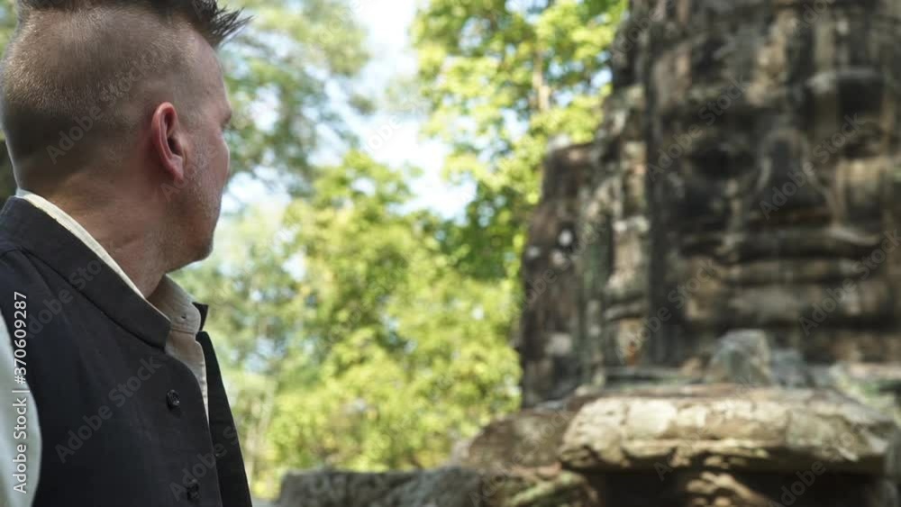 Tourist in Bayon Temple with the Famous Buddha Stone Ruins Tourist in Bayon Temple with the Famous Buddha Stone Ruins