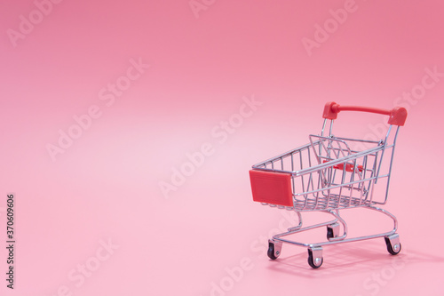 Shopping concept - Empty red shopping cart on pink background. online shopping consumers can shop from home and delivery service. with copy space.