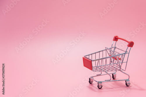 Shopping concept - Empty red shopping cart on pink background. online shopping consumers can shop from home and delivery service. with copy space.