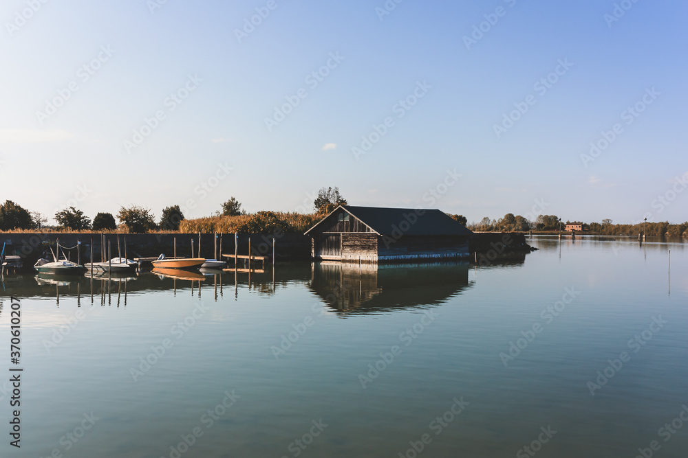 boats stands near boathouse in a lake