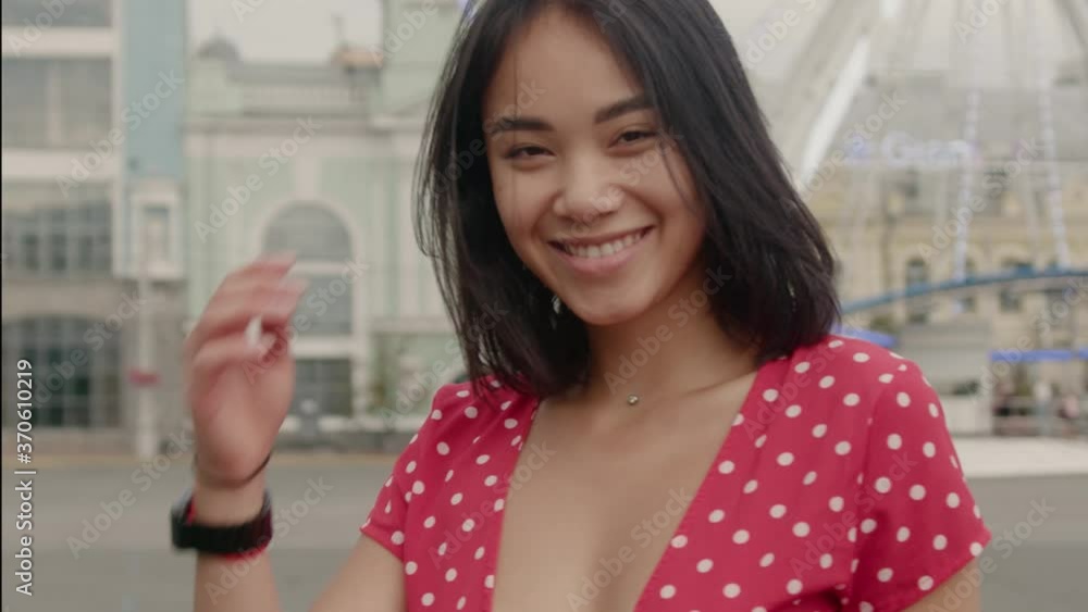 Shot of young attractive woman look at camera at city center feel happy smiling fashion girl summer face sun beautiful slow motion Shot of young attractive woman look at camera at city center feel happy smiling fashion girl summer face sun beautiful slow motion