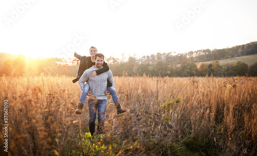 Young couple in love on a walk in autumn forest  holding hand ribbon kites.