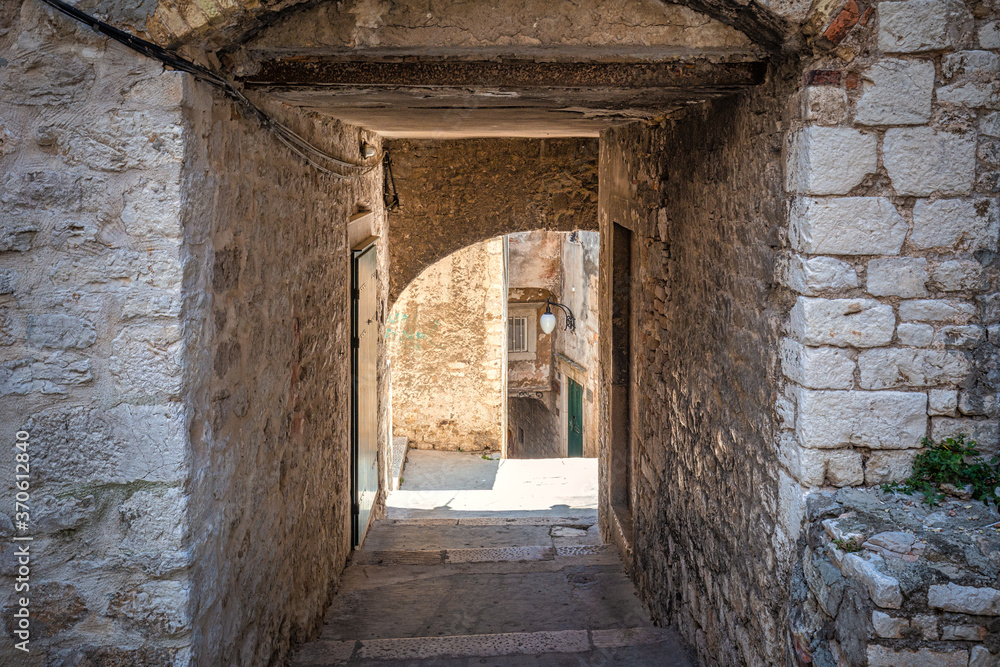 Street with a historic architecture in Sibenik. An ancient city on the Dalmatian coast of Adriatic sea in Croatia, Europe. Street with a historic architecture in Sibenik. An ancient city on the Dalmatian coast of Adriatic sea in Croatia, Europe.