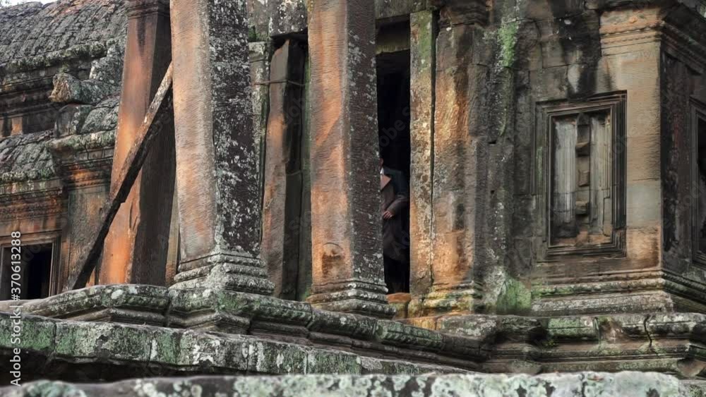 Man Sprinting Out from the Tombs in a Cambodian Temple Man Sprinting Out from the Tombs in a Cambodian Temple