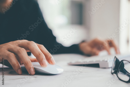 Closeup businessman using computer mouse with computer keyboard