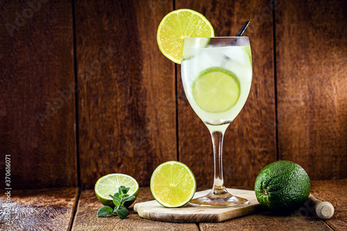 glass of caipirinha, typical drink from brazil, on rustic wooden background, national caipirinha day, 13th of september photo