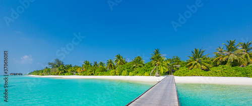 Fantastic paradise beach. Maldives island beach panorama. Palm trees and beach bar and long wooden pier, jetty pathway. Tropical vacation and summer holiday background concept  © icemanphotos