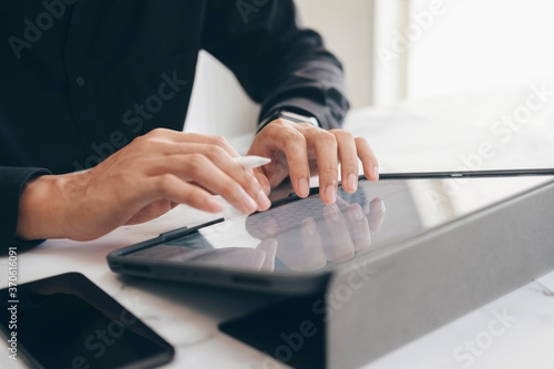 Close-up of young businessman hands working with tablet