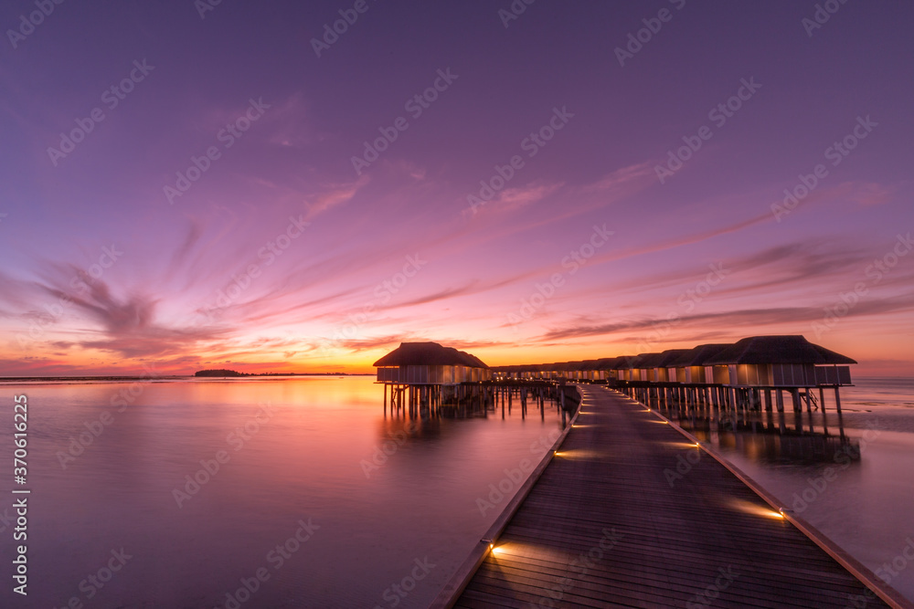 Sunset on Maldives island, luxury water villas resort and wooden pier. Beautiful sunset sky and clouds and tropical beach background for summer vacation holiday and travel concept banner
Sunset on Maldives island, luxury water villas resort and wooden pier. Beautiful sunset sky and clouds and tropical beach background for summer vacation holiday and travel concept banner