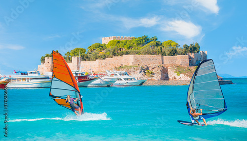 Windsurfer surfing the wind on waves in Kusadasi - Pigeon Island with a "Pirate castle" Kusadasi harbor, Aegean coast of Turkey