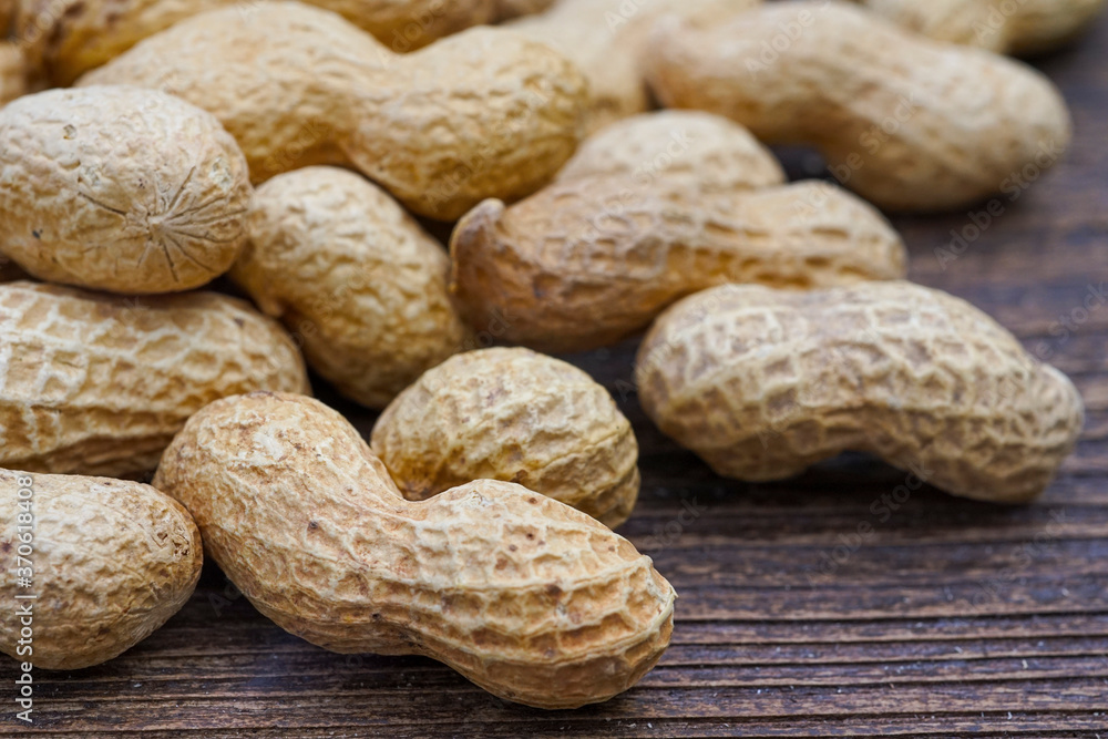 peanuts in peel texture closeup on wooden background peanuts in peel texture closeup on wooden background
